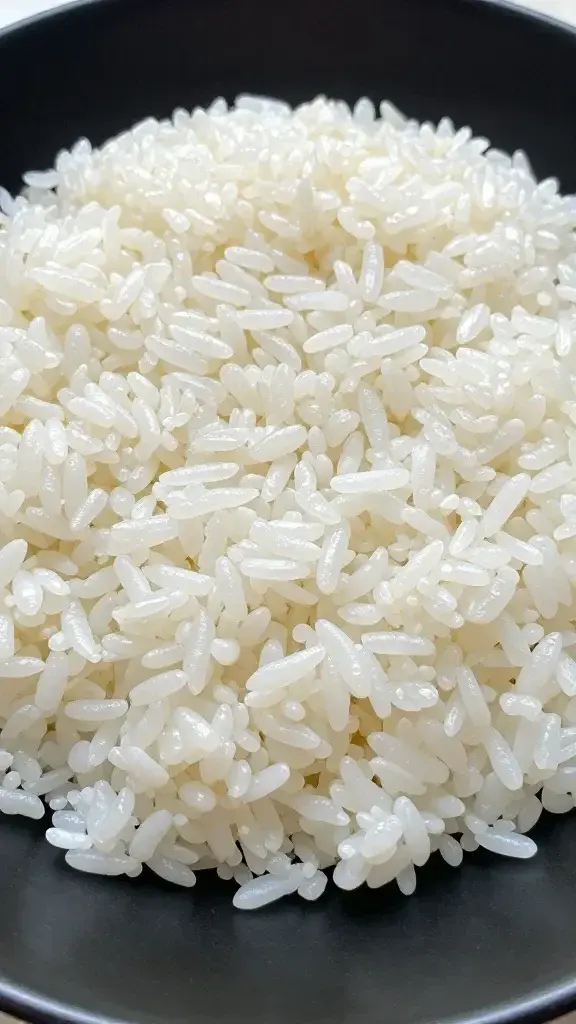 Closeup of fluffy jasmine rice mound on black plate