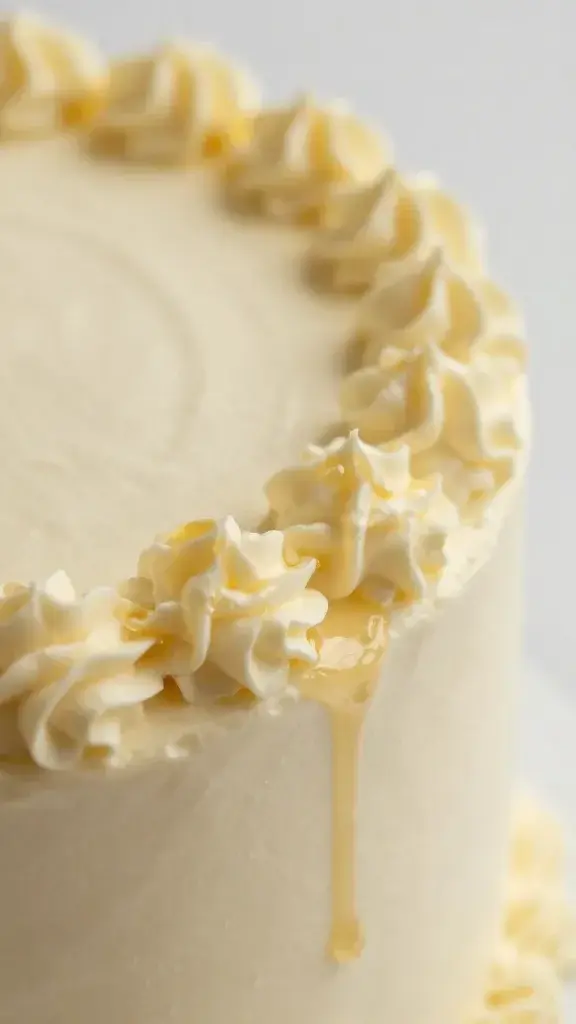 Closeup: light honey frosting glaze on cake edge detail